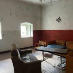 Knast Gräfentonna: Raum mit Sofas und rot gestrichener Wand